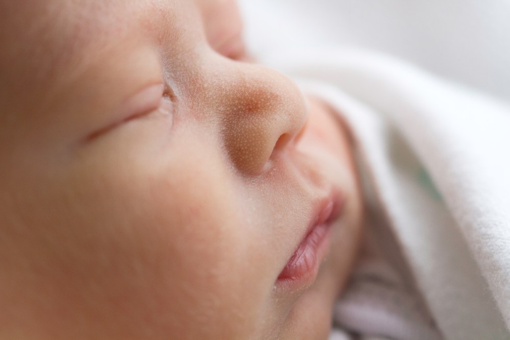 Macro photograph of a newborn face. Side profile. Baby lips