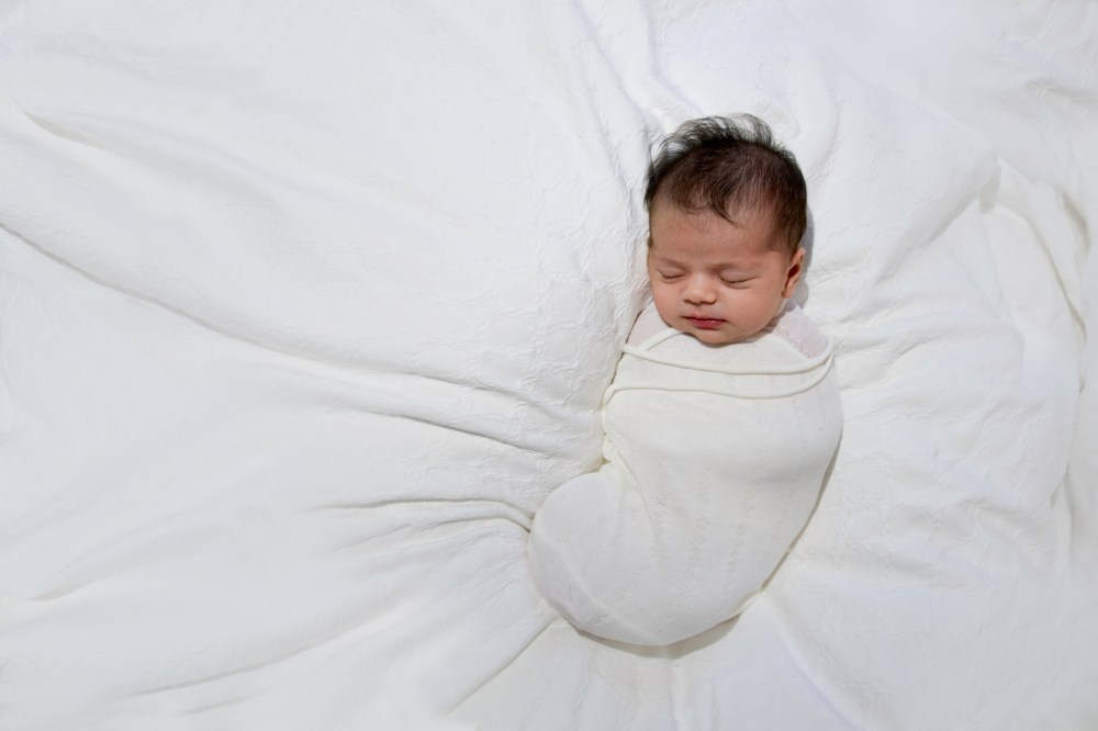 Wrapped newborn sleeping, photographed during lifestyle session