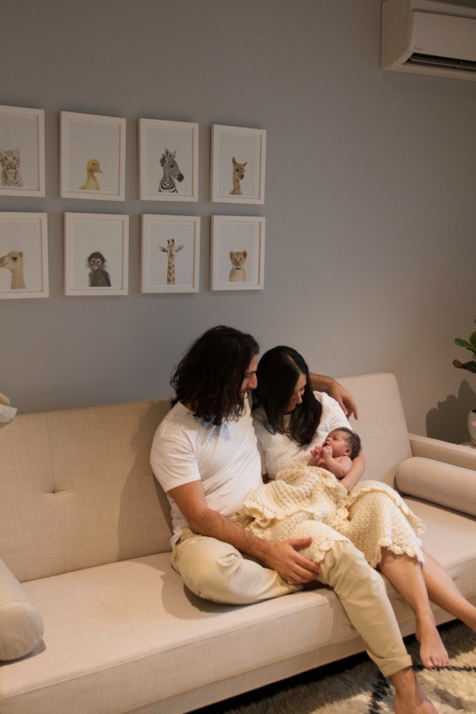 Lifestyle newborn session. Parents with newborn in the nursery.